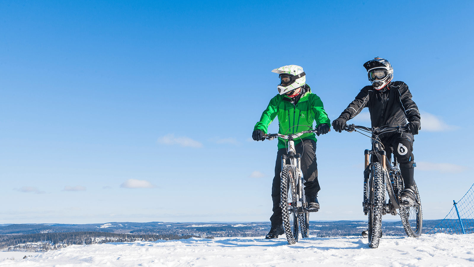 Two persons riding fatbikes in winter