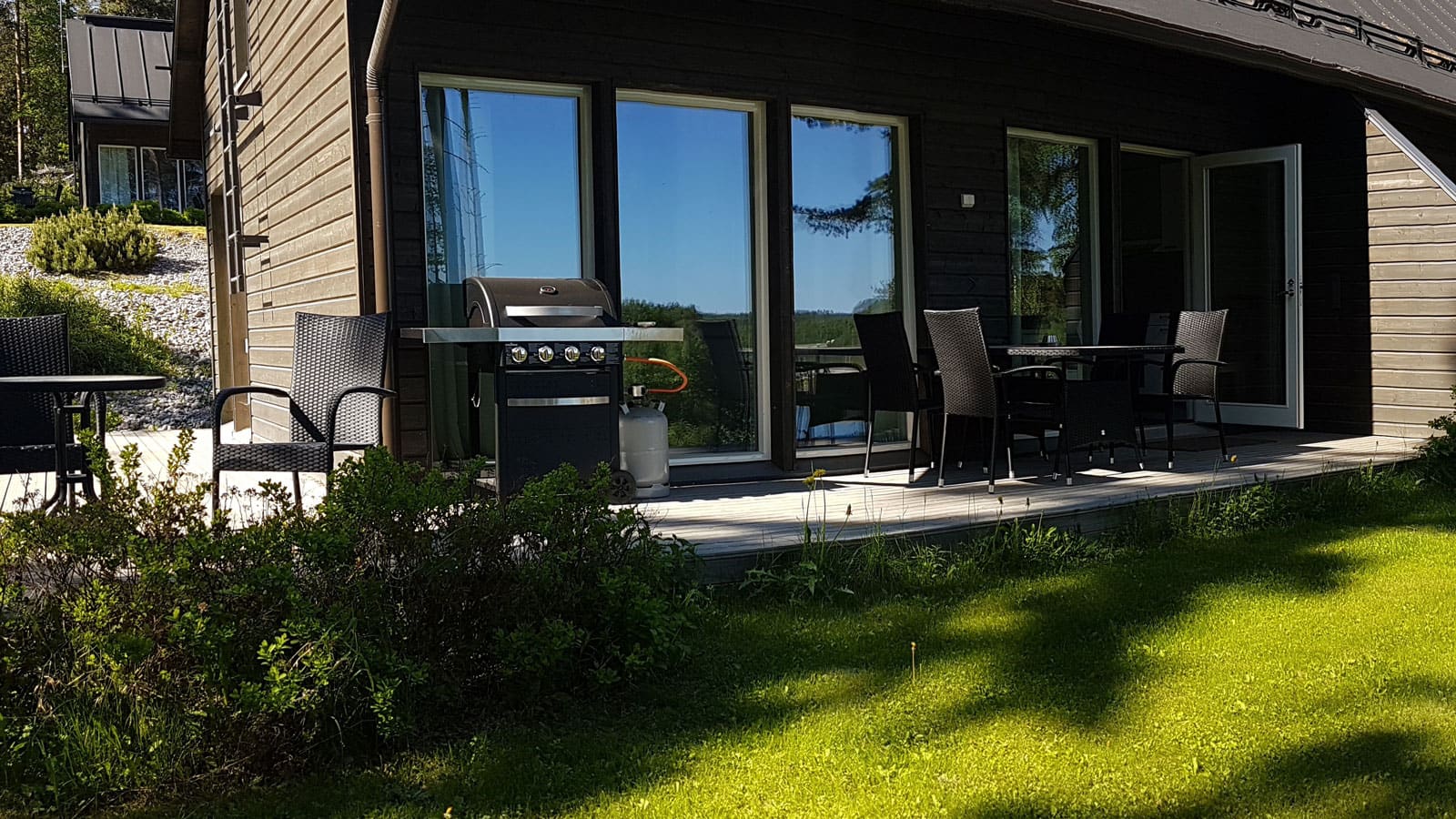 Terrace with table, chairs and grill.