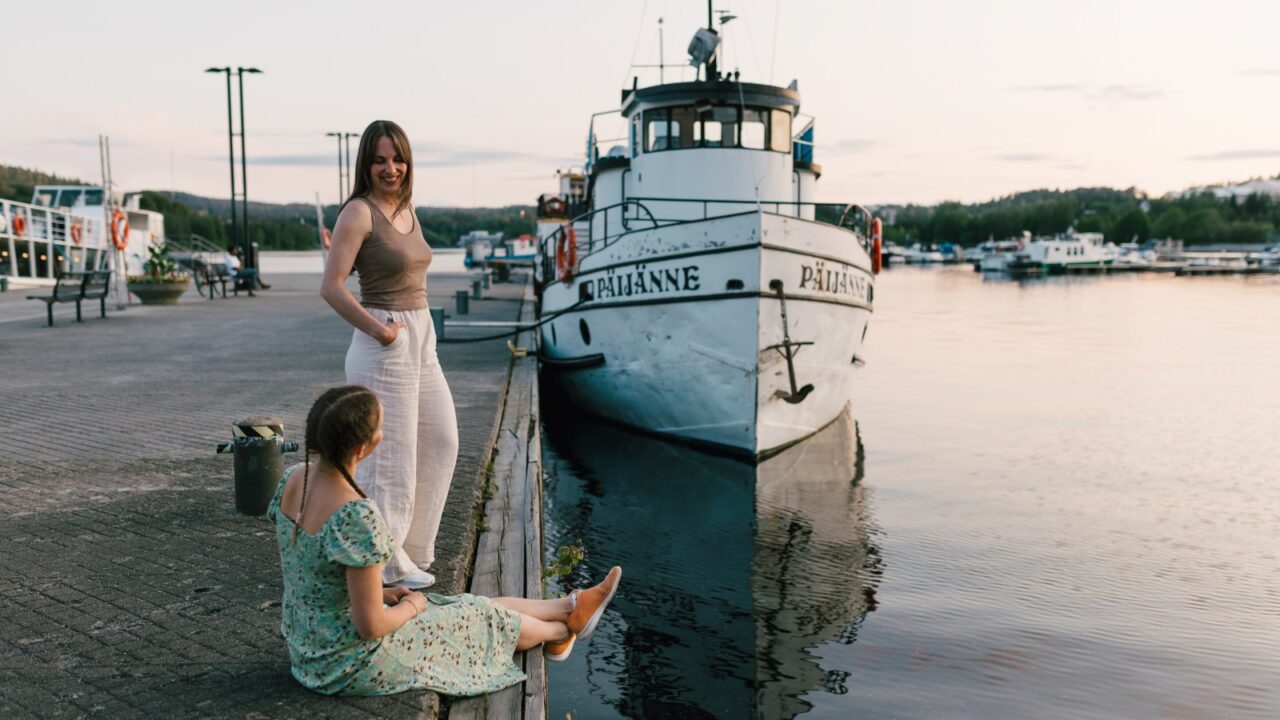 Kaksi henkilöä Jyväskylän Lutakon satamassa, taustalla näkyy Päijänne-niminen laiva.