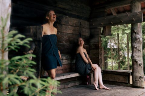 Two people in front of a smoke sauna.