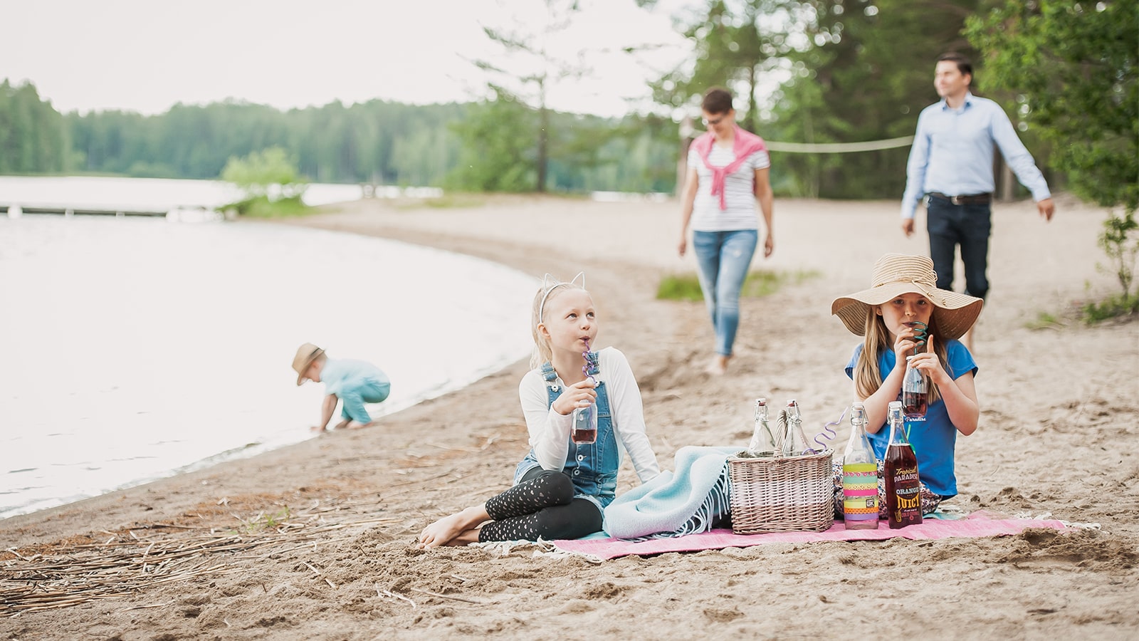 Three children and two adults at the beach at Piispala