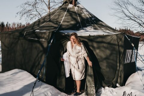 Jemand verlässt eine Zeltsauna im Winter