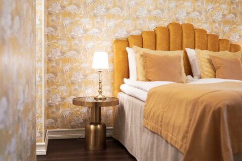 Bed decorated with yellow textiles in a hotel room