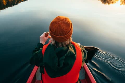 Henkilö meloo järvellä.