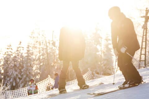 Henkilöitä laskettelemassa aurinkoisessa Laajavuoressa
