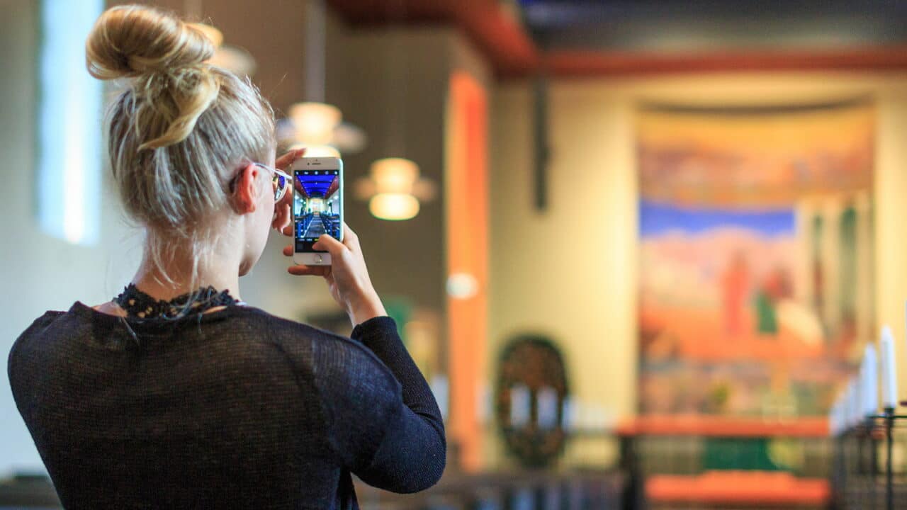 A person takes a photo by phone inside Muurame Church