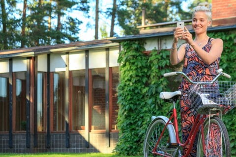 Person with a bike standing in front of the Säynätsalo City Hall.