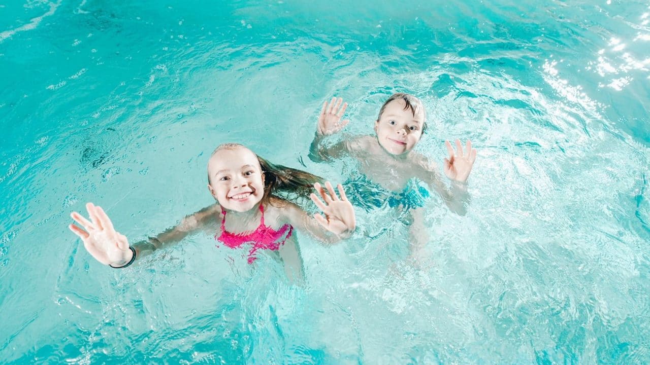 Two children swimming in a pool