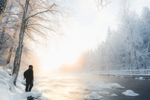 Henkilö talvisen Konnekosken rannalla.
