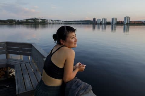 Una persona en una plataforma de sauna frente a Lutakko.