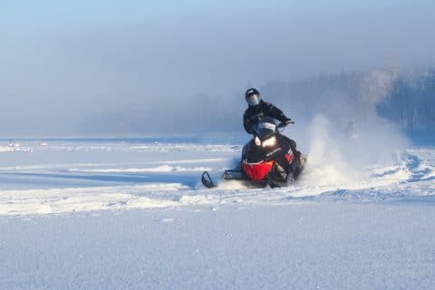 Persona que conduce una moto de nieve.
