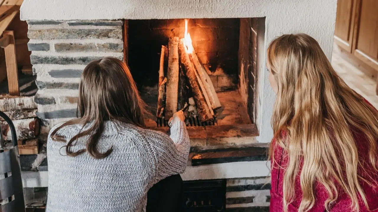 Kaksi henkilöä istumassa takan edessä