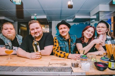 Viisi henkilöä baaritiskin takana