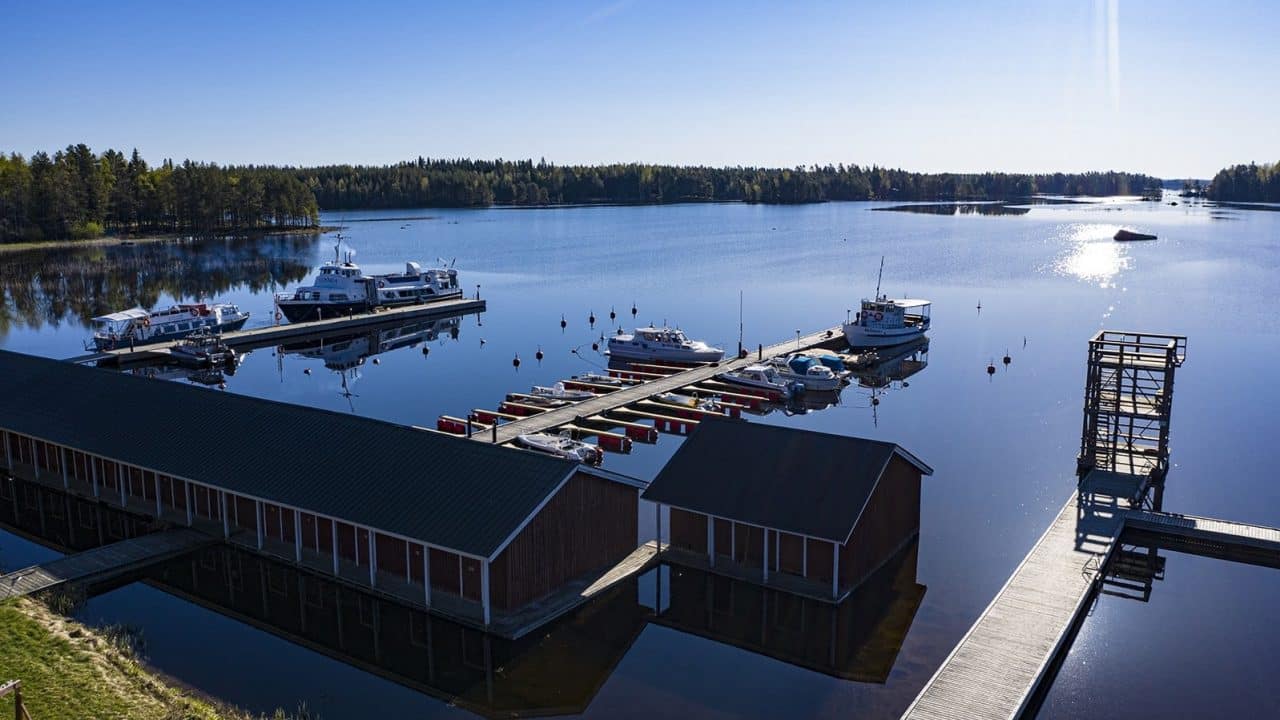 Ilmakuva Häyrylänrannan laitureista, jossa muutamia veneitä ja upea järvimaisema.
