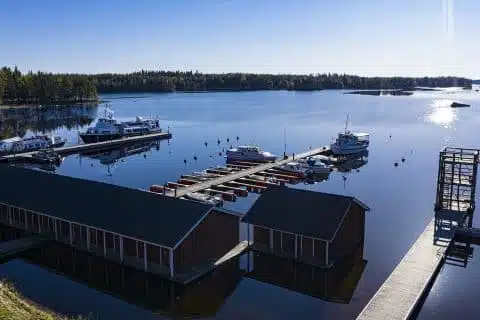 Ilmakuva Häyrylänrannan laitureista, jossa muutamia veneitä ja upea järvimaisema.