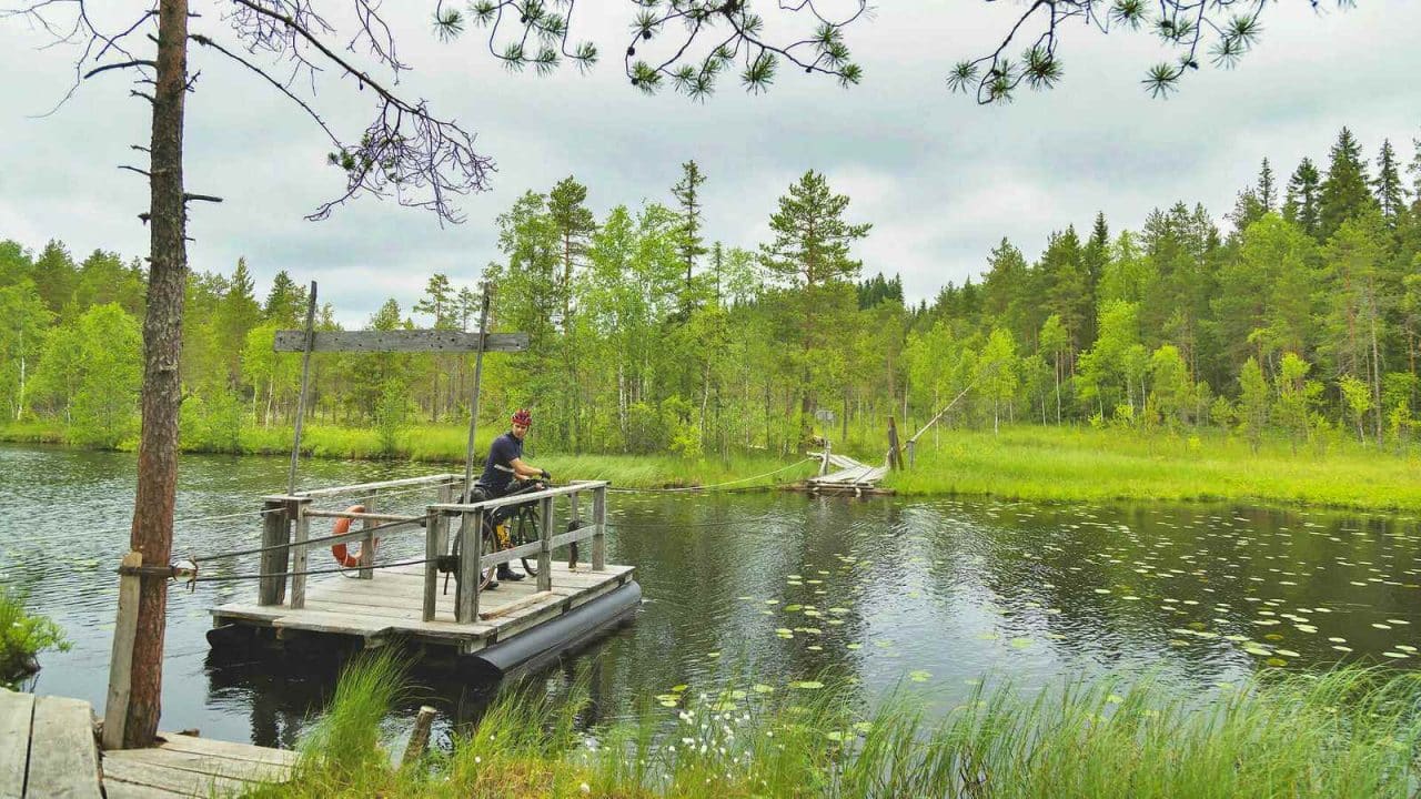 A person is crossing a river using a rope ferry.