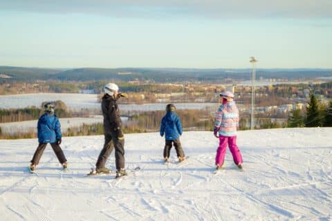 Four childen on the top of a slope in Laajavuori skiing centre.