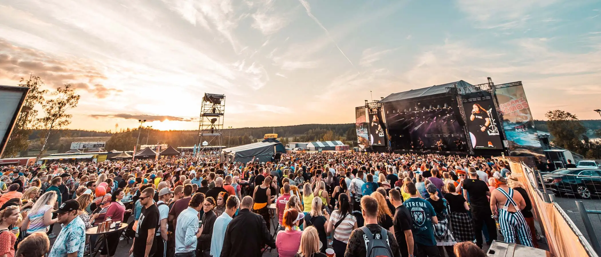 Suuri ihmisjoukko kokoontunut seuraamaan musiikkiesitystä Himoksella auringon laskiessa