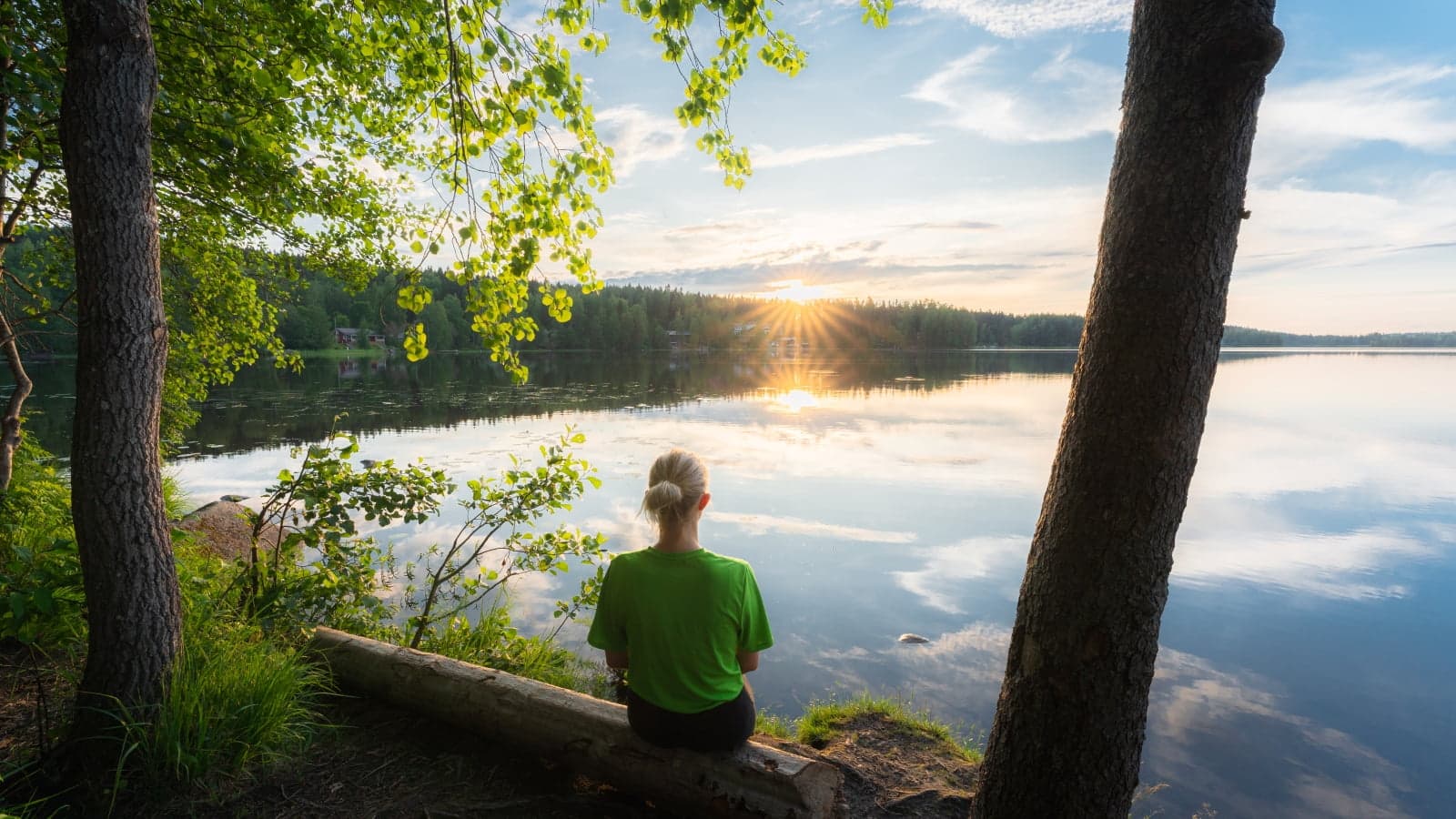Henkilö istuu Tuomiojärven rannalla Jyväskylässä.