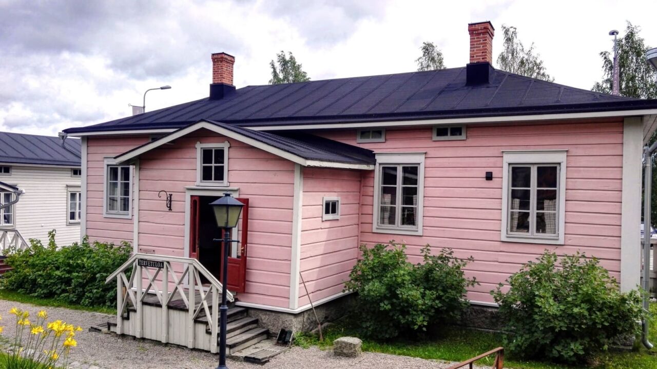 Vaaleanpunainen kuparisepän talo ulkoa.