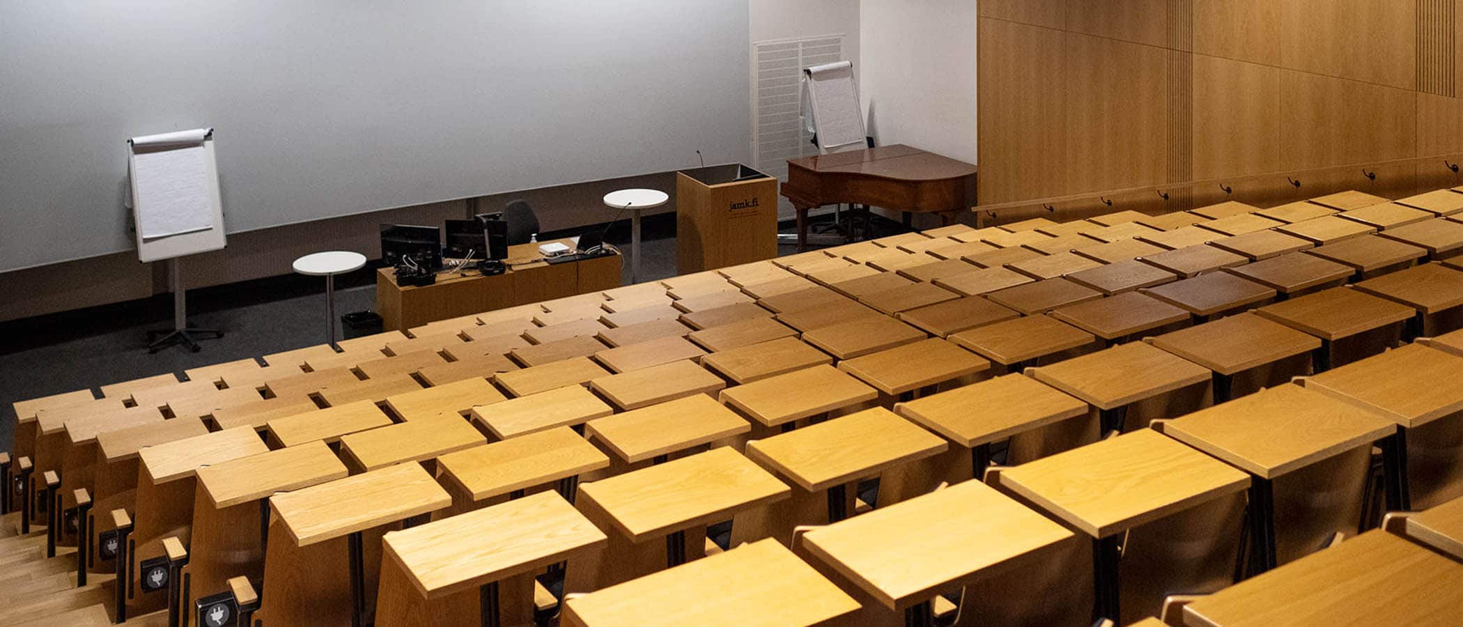 Puisia auditoriopöytiä rivissä laskevassa katsomossa