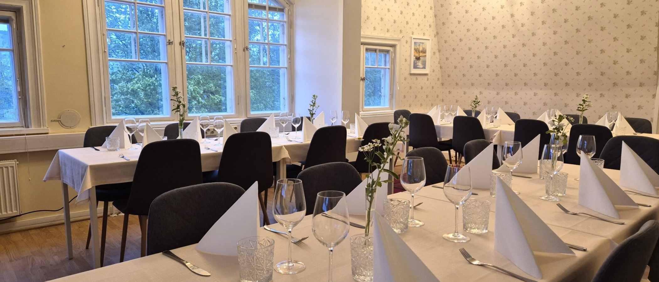 Long tables set in a bright banquet hall.