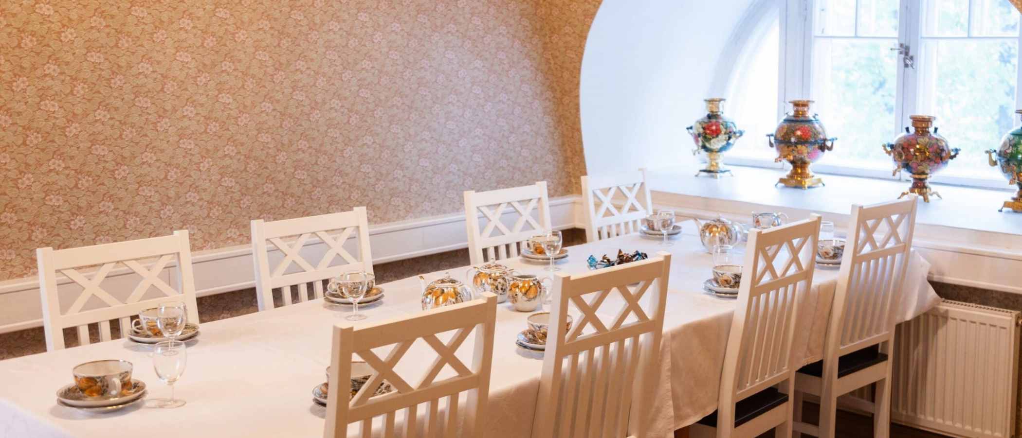 A long table set with decorative teacups.