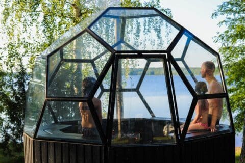 Un adulto y dos niños en una sauna iglú.