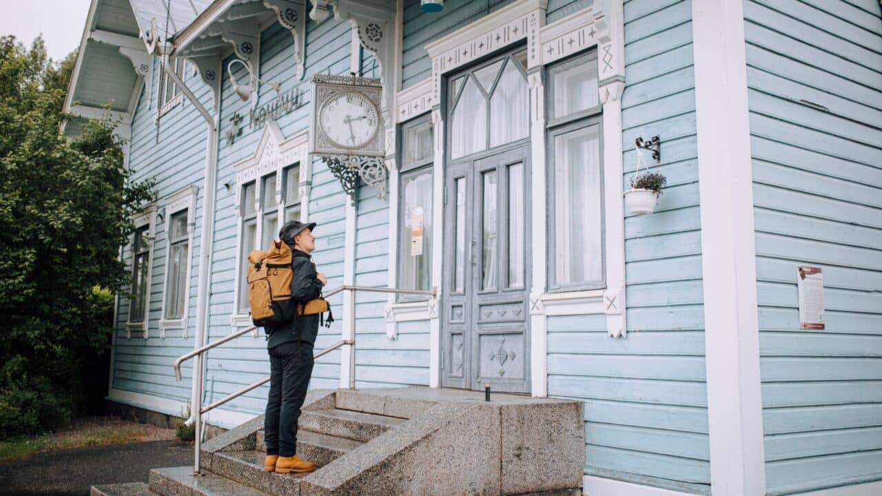 Person standing on stairs in front of the old railways station in Keuruu.