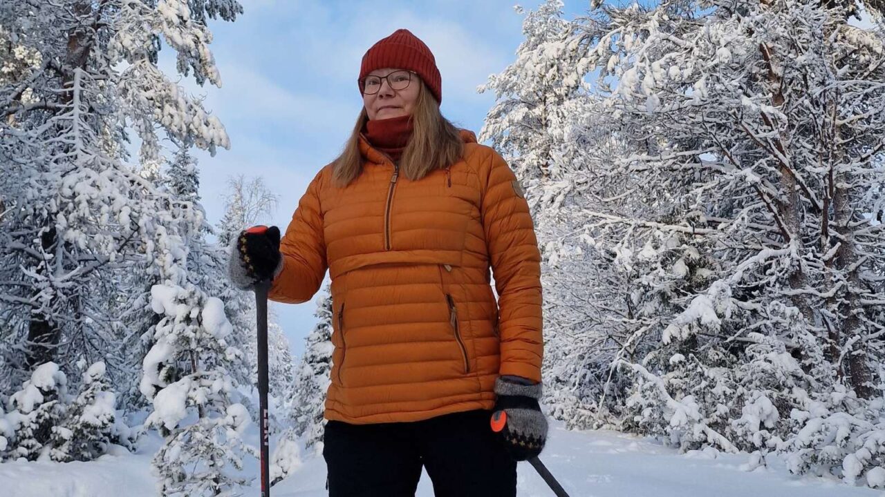 Henkilö lumikenkäilee talvisessa metsässä.