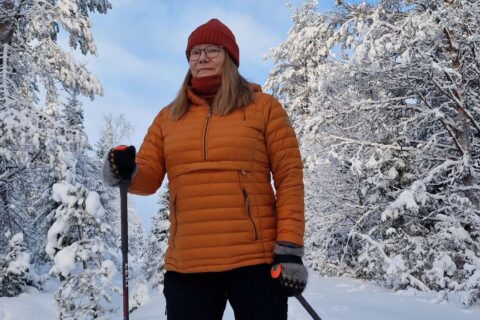 Henkilö lumikenkäilee talvisessa metsässä.