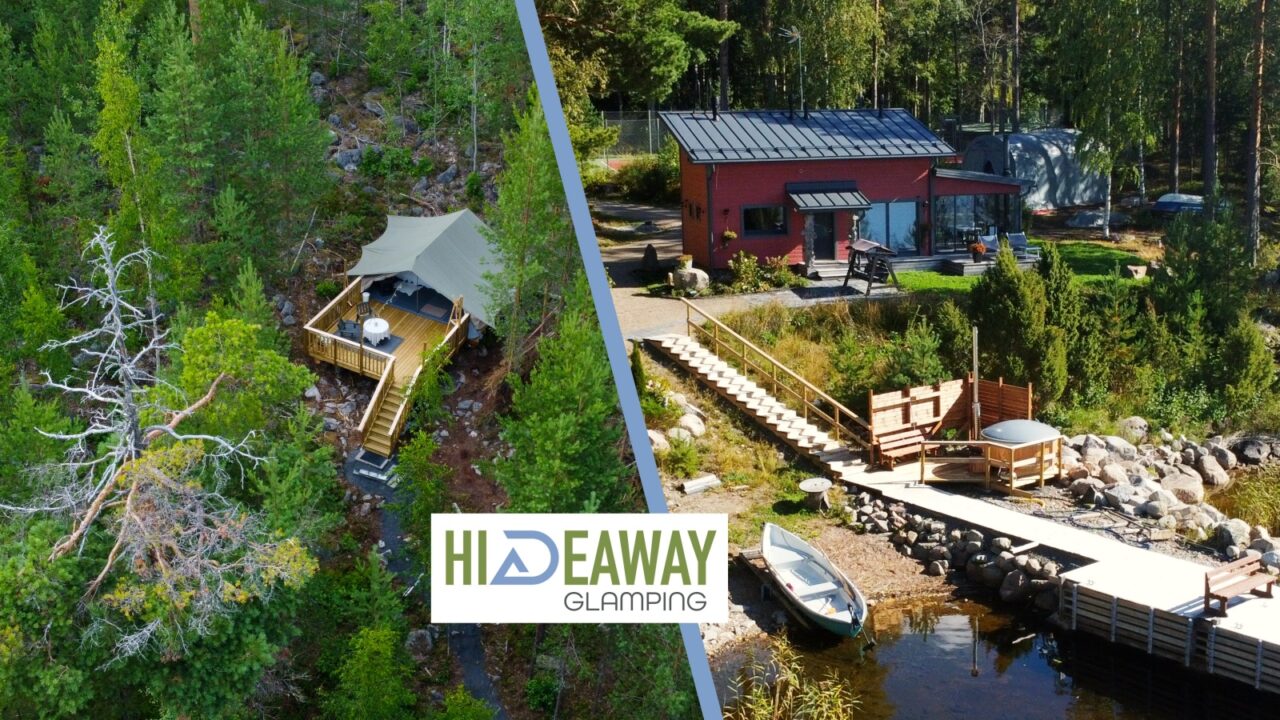 Glamping majoite luonnon keskellä ja saunarakennus kuvattuna järveltä.