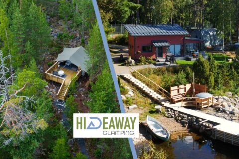 A glamping accommodation surrounded by nature and a sauna building photographed from the lake.