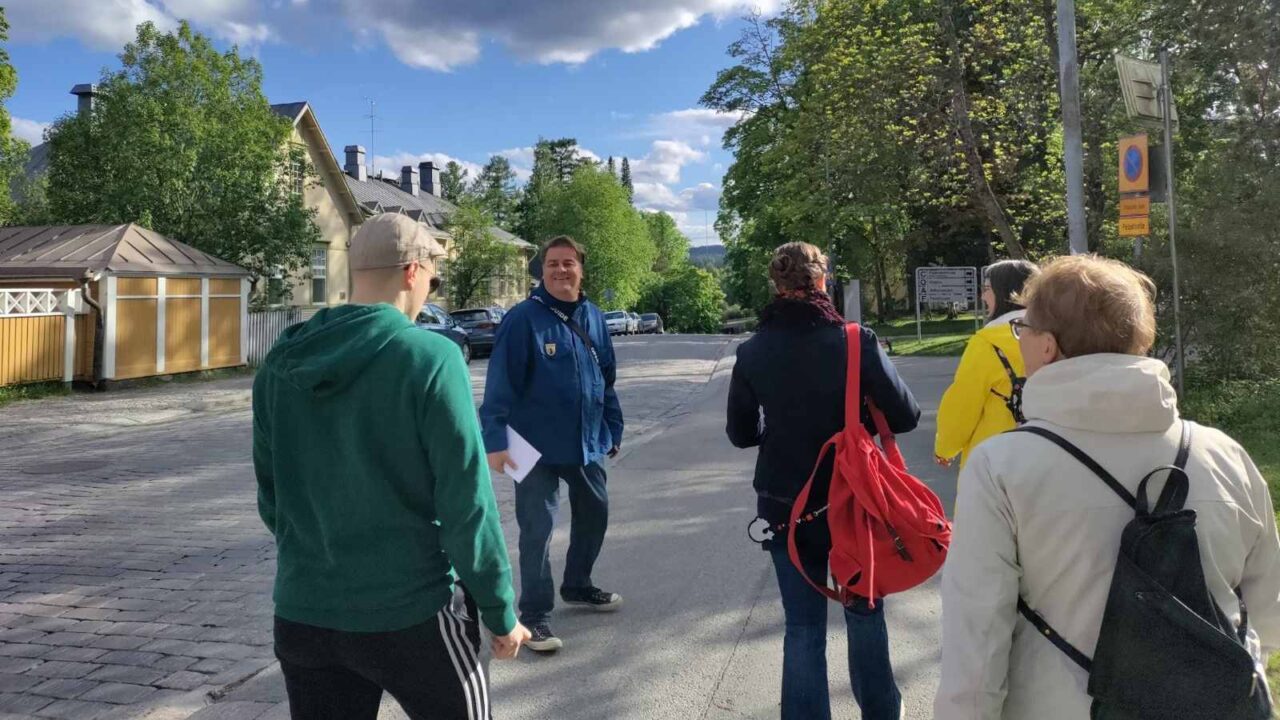A city guide leading a group down a summer street