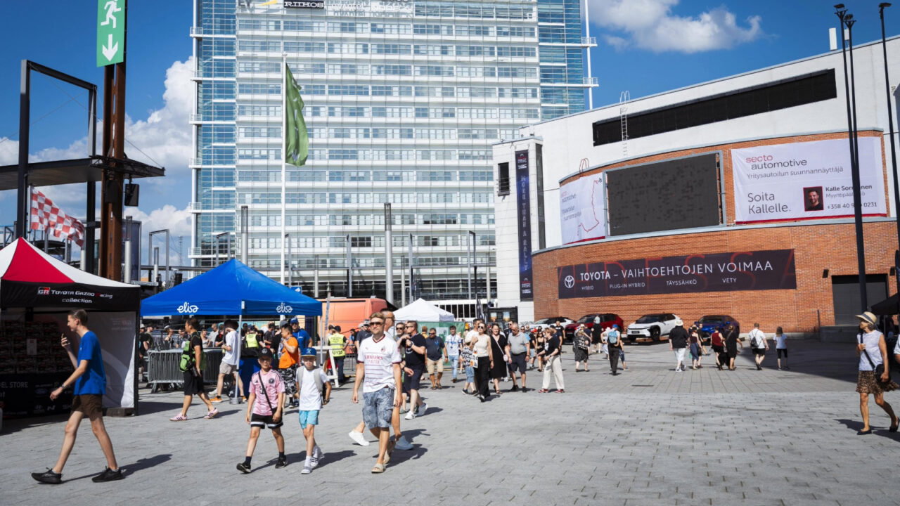 Ihmisiä kulkemassa Paviljongin ympyrätorilla Suomen MM-rallin huoltoparkissa.