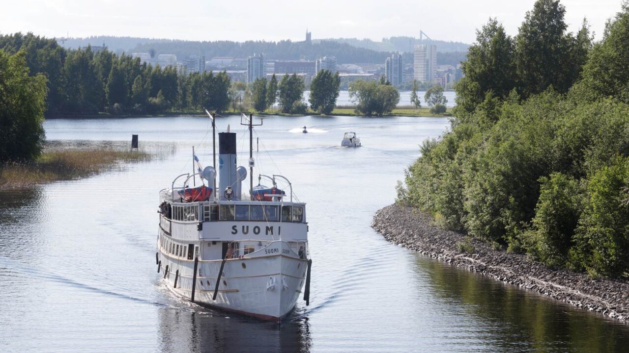 Suomi-höyrylaiva lipuu pitkin kanavaa, taustalla näkyy Jyväskylän Lutakko.