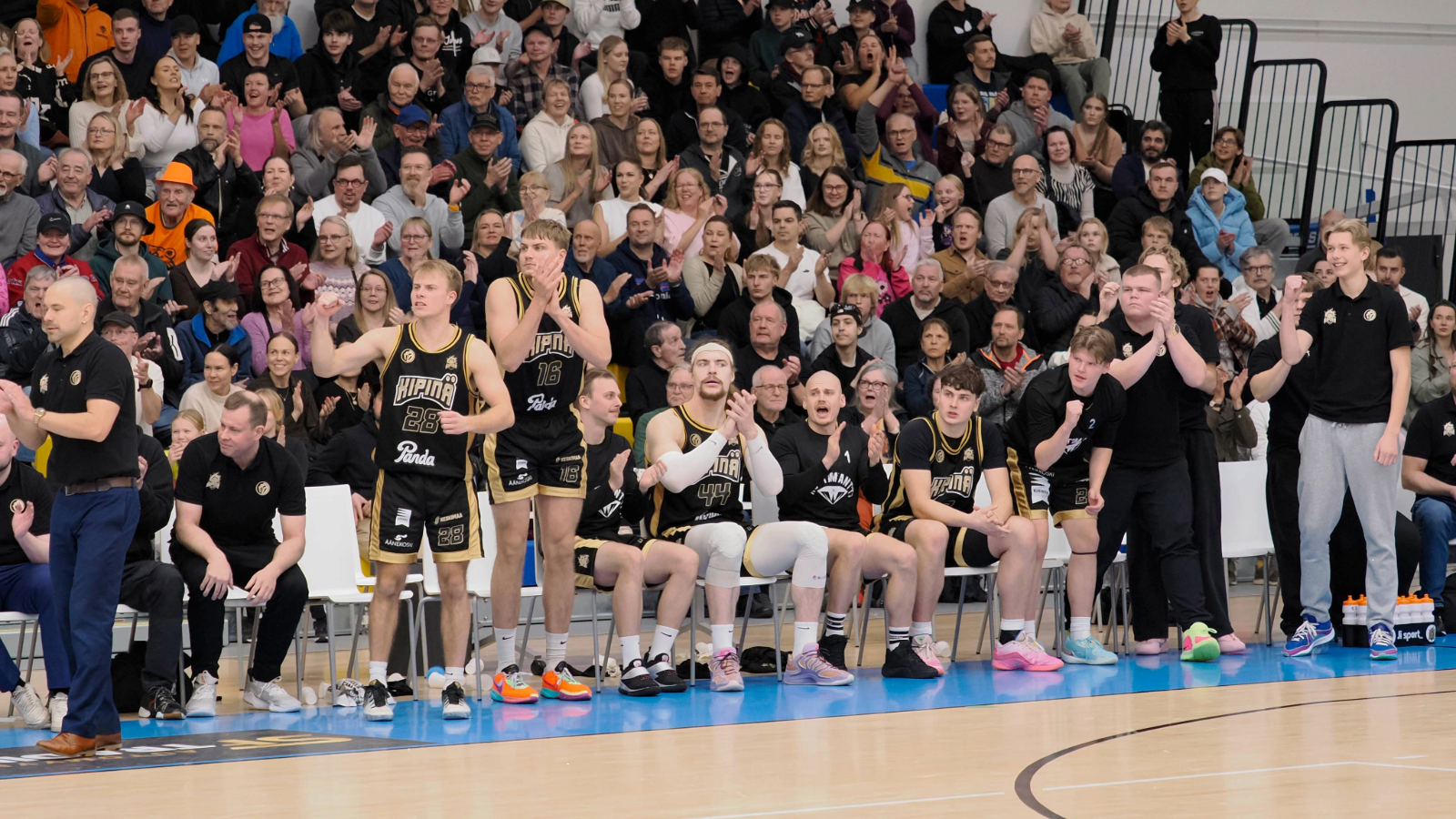 Kipinä Basketin koripallojoukkue yleisön edessä.